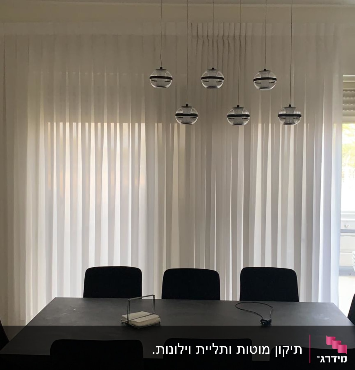 וילון לבן שקוף תלוי על חלון גדול